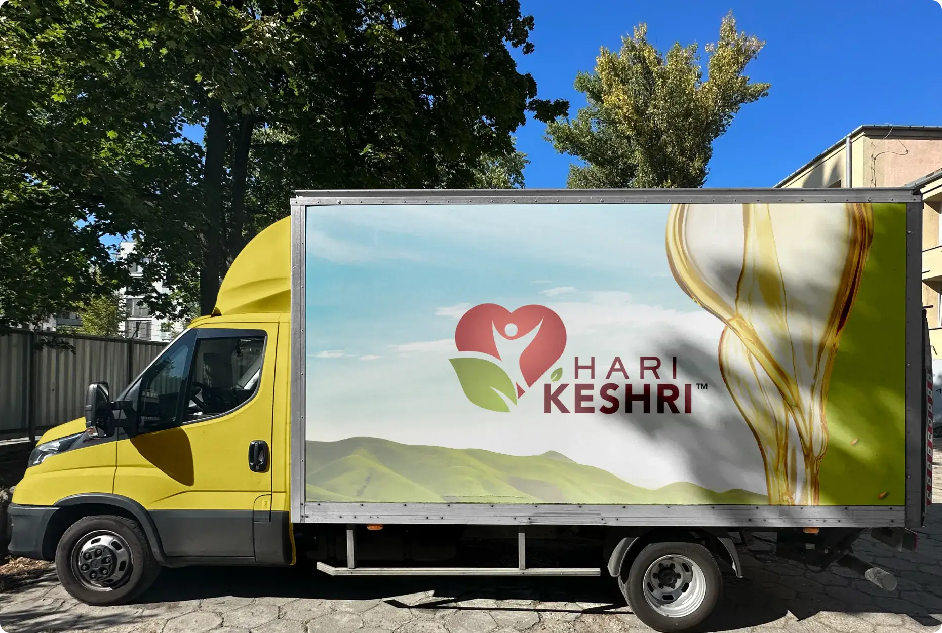 Hari Keshri-branded delivery truck featuring logo and scenic design.
