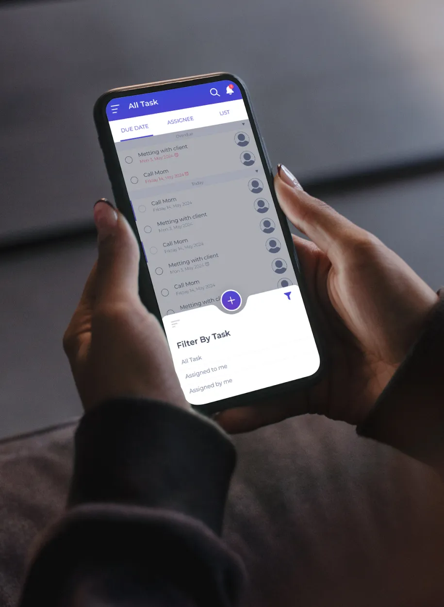 Person holding a smartphone displaying a task management app with a 'Filter By Task' popup.